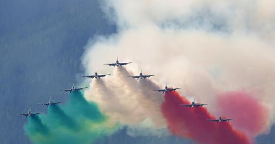 Aerei colorano il cielo con fumi verde, bianco e rosso, creando un'emozione patriottica.