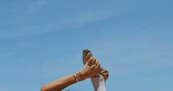 Ballerina in equilibrio sul mare, eleganza e forza in un'immagine serena.