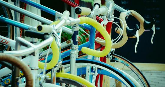 Biciclette colorate allineate, manubri avvolti, evocano libertà e avventura.