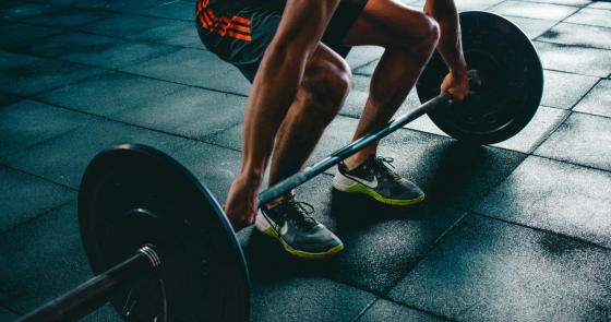 Atleta solleva pesi in palestra, forza e concentrazione.