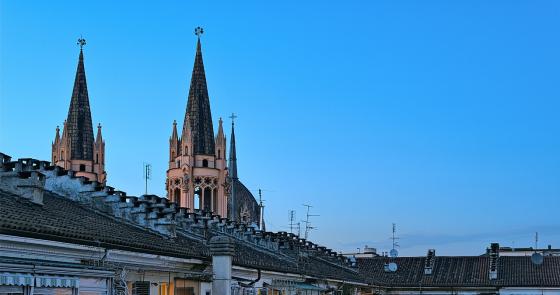 Torri gotiche svettano su un cortile antico al tramonto.