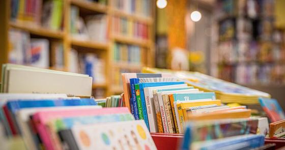 Colorati libri per bambini su scaffali di una libreria accogliente.