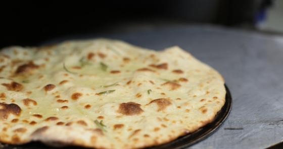Pane croccante al forno, profumato e invitante, con erbe fresche.