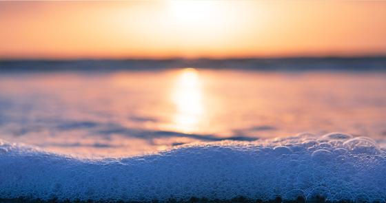 Tramonto sul mare, schiuma delicata, colori caldi e atmosfera serena.