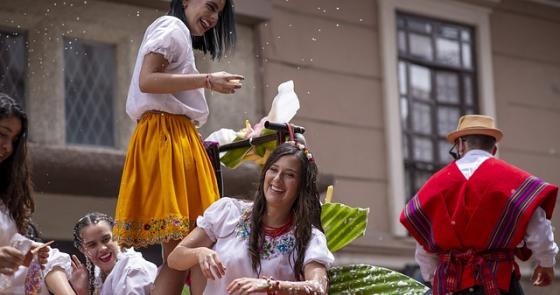 Persone sorridenti in abiti tradizionali, celebrano con gioia e allegria una festa all'aperto.