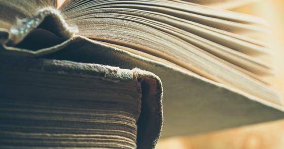 Vecchi libri aperti, pagine ingiallite, atmosfera di saggezza e nostalgia.