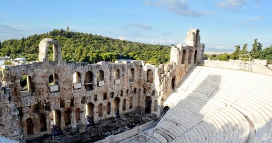 Antico teatro greco, maestoso e silenzioso, immerso nella natura.