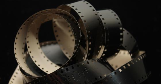 Pellicola cinematografica avvolta, simbolo di nostalgia e magia del cinema.