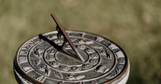Meridiana antica in bronzo, simboli zodiacali, ombra che segna il tempo.