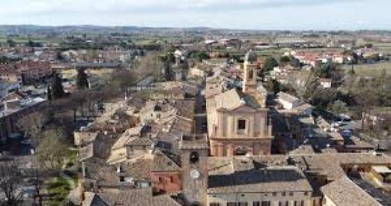Vista panoramica di un borgo antico con tetti in terracotta e campagna circostante.